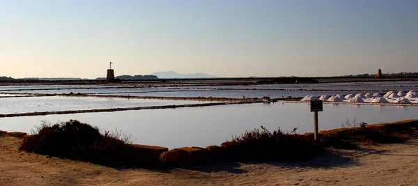 Gün batımında tuz düzlükleri kule ve arka planda promontuar