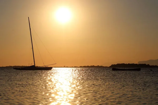 Yelkenli ve kano gün batımında denize demirlemiş ve arka planda da buruna.