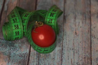 Masada kırmızı domatesler ve yeşil mezura var.