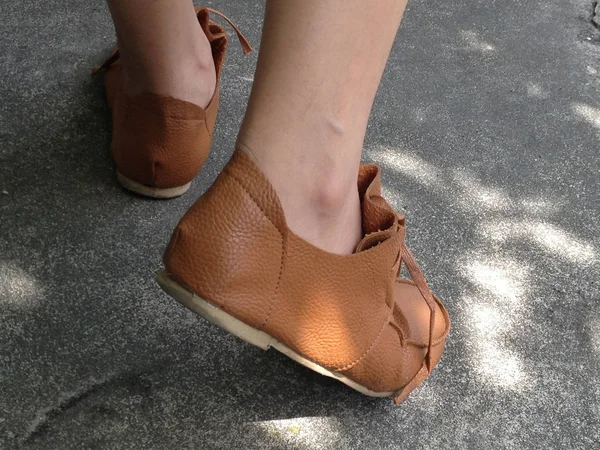 Žena nosí hnědé boty chůzi na šedé betonové ulici Royalty Free Stock Fotografie