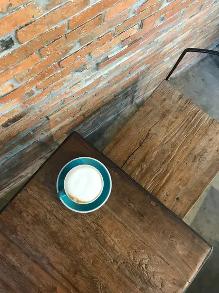 Café con leche caliente en una taza azul-verde en la mesa de madera —  Fotos de Stock