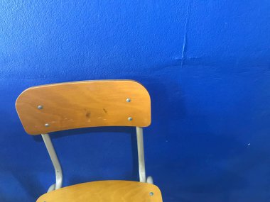 Kahverengi boş okul sandalyeleri ve arka planda mavi duvar