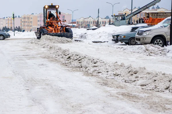 Usuwanie zagęszczonego śniegu z drogi przy użyciu ciężkiego sprzętu do usuwania śniegu i równiarki — Zdjęcie stockowe