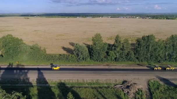 Penggerak jalan melakukan perbaikan dan paving jalan amoung ladang — Stok Video