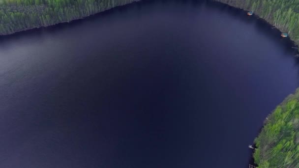 Volando sobre el lago contra los bosques de abetos y pinos. Colección de drones — Vídeo de stock