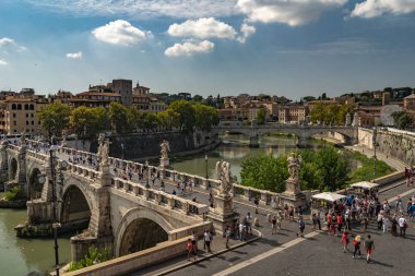 Köprüdeki Castel Sant 'Angelo' nun güzel manzarası üzerinde yürüyen insanlar ve Tiber nehri. Roma 'da güzel güneşli bir hava, Roma' da peri masalı gibi..