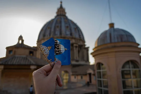 Dívka drží dva lístky do kupole baziliky svatého Petra z Vatikánu na střeše před kupolí. Soustředí se na lístky, rozmazané pozadí na střeše — Stock fotografie