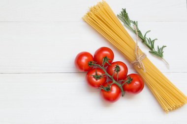 Spagetti malzemeleri, domates, biberiye, beyaz arka plan manzaralı konsept.