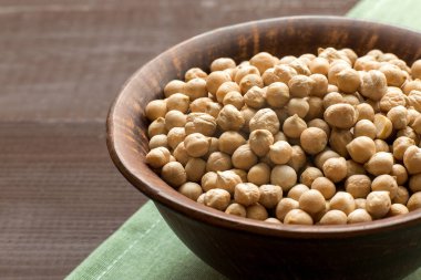 Tabakta çiğ nohut, koyu ahşap arka plan, kapat.