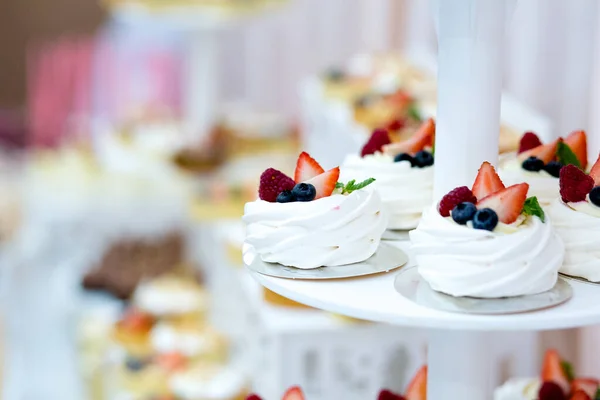 Delicious sweet buffet with cupcakes, sweet candy bar with cupcakes and meringues and other desserts, close up
