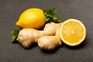 Bağışıklık için sağlıklı ürünler, limon, nane, siyah arka planda zencefil, üst görünüm