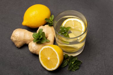 Bağışıklık, limon, nane, zencefil, siyah zemin üzerinde bir bardak su, üst görünüm için sağlıklı ürünler