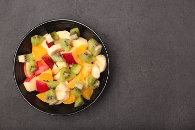 Taş arka planda kasede taze meyve salatası fotokopi alanı
