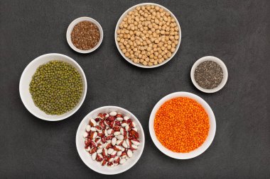 Koyu arkaplan, mercimek, nohut, bezelye, fasulye, keten tohumu, tabakta chia, fotokopi alanı, üst görünüm