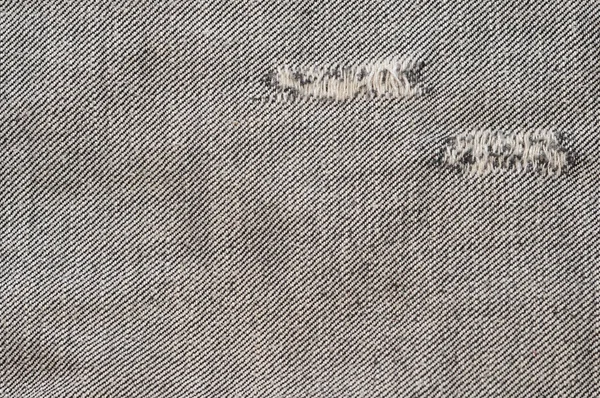 擦り切れている穴に、黒い布の gr と背景をテクスチャのデニム ジーンズ — ストック写真