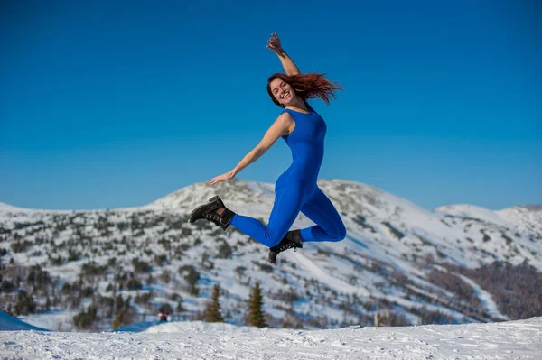 A garota na roupa azul fazendo ioga no topo de uma montanha — Fotografia de Stock