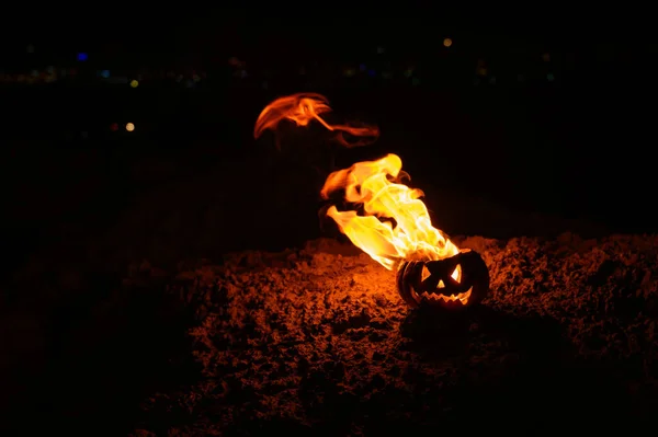 Lenguas de llama en una calabaza. Jack-o-linterna en llamas sobre un fondo negro. Símbolo de Halloween en el suelo. Truco o trato. De cerca. . — Foto de Stock