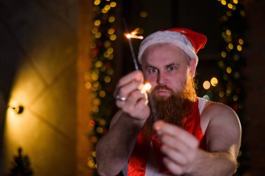 Noel Baba tatilde ışıldıyor. Noel Baba şapkalı kızıl sakallı bir adam yeni yılı kutluyor..