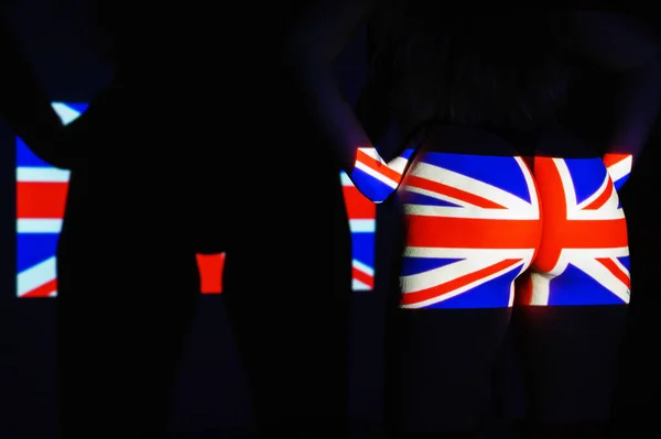 La proiezione della bandiera del Regno Unito su un bel culo femminile di grandi dimensioni. Il proiettore brilla con una bandiera dell'Inghilterra su un corpo femminile. Britannico — Foto Stock