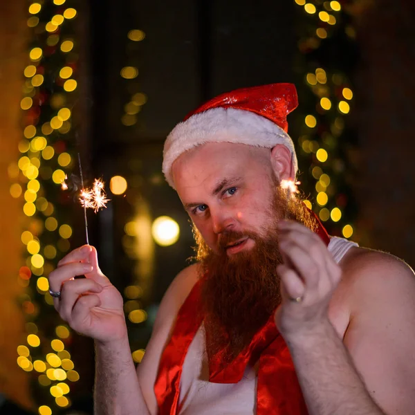 Santa con destellos de Navidad en vacaciones. Un hombre con barba roja en un sombrero de Papá Noel celebra el Año Nuevo . —  Fotos de Stock