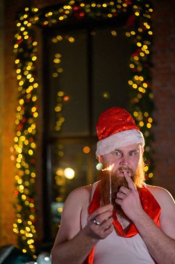 Noel Baba tatilde ışıldıyor. Noel Baba şapkalı kızıl sakallı bir adam yeni yılı kutluyor. Mutlu yıllar ve Noel.