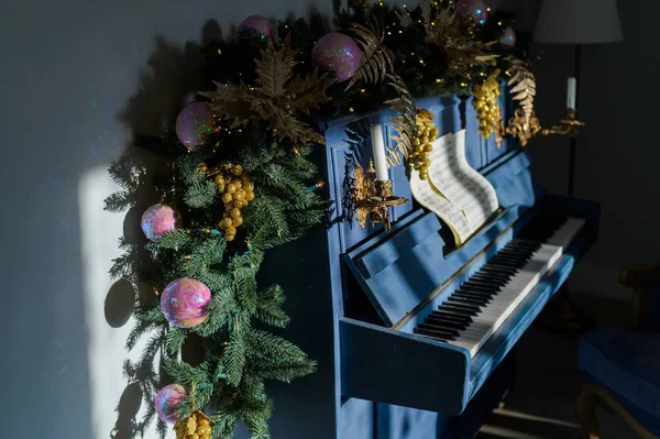蓝色大钢琴上的特写圣诞装饰。 新年快乐。 云杉树枝躺在钢琴上. — 图库照片