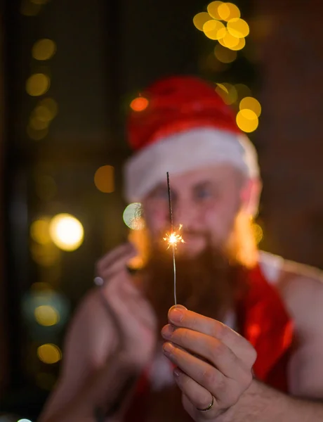 Santa s vánoční jiskry na dovolené. Muž s červeným vousem v klobouku Santa Clause slaví Nový rok. Štěstí na Vánoce. — Stock fotografie