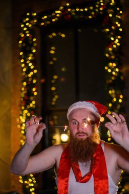 Noel Baba tatilde ışıldıyor. Noel Baba şapkalı kızıl sakallı bir adam yeni yılı kutluyor..