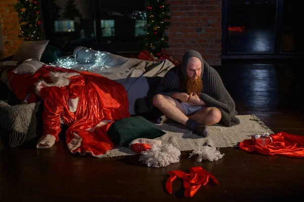 Rossz Mikulás a háttérben a karácsonyi dekorációk. Egy férfi a Télapó öltönyében az Újév után.. — Stock Fotó