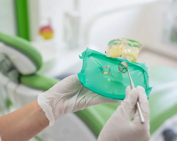 Un primo piano della disposizione del dente umano con diga in gomma. I dentisti mettono i guanti. Il medico indica il processo di trattamento dentale della mascella artificiale. cofferdam . — Foto Stock