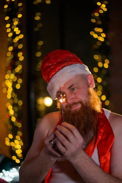 Noel Baba tatilde ışıldıyor. Noel Baba şapkalı kızıl sakallı bir adam yeni yılı kutluyor. Noel 'de mutluluk.