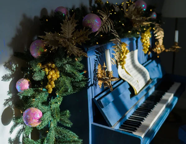 Close-up Christmas decoration on blue grand piano. Happy new year. The spruce branch lies on the piano. — Stockfoto