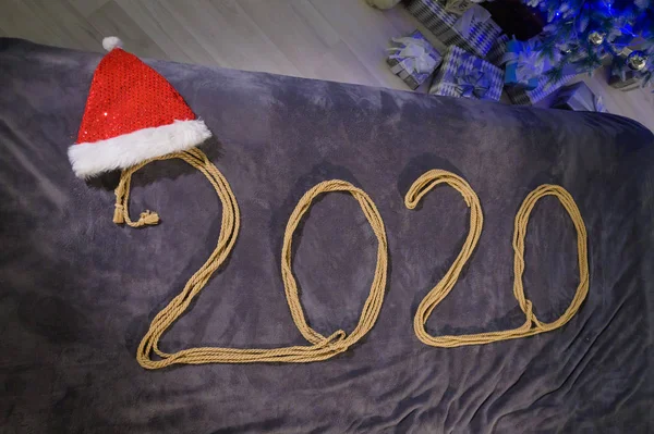 Šťastný Nový rok2020. Nápis z provazu na posteli. čepice Santa Claus. — Stock fotografie