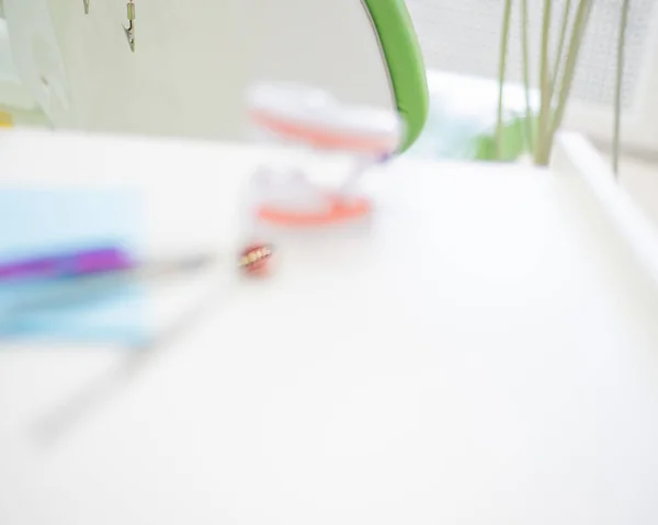 Los instrumentos estériles están en el consultorio del dentista. Un espejo, pinzas, una sonda y un diseño de mandíbula están en la mesa de ortodoncistas. Higiene bucal, prevención de caries, examen . —  Fotos de Stock