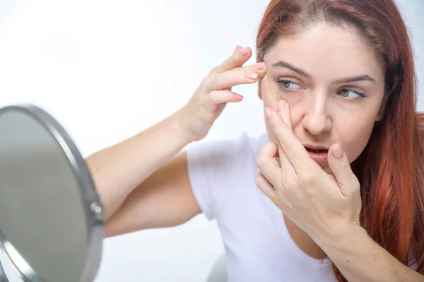 Porträtt vacker rödhårig kvinna med kinesiologi ansiktslyftning tejp. Flicka kosmetolog sätter på ansikte kinsio tejp för ansiktslyftning. — Stockfoto