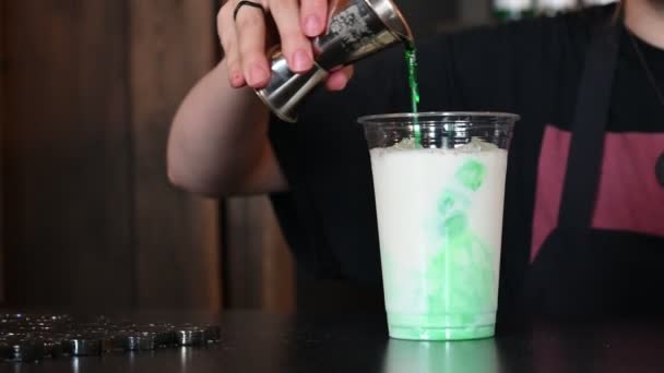 Making iced takeaway coffee. Barista is preparing a cold green coffee drink. Frappe with mint syrup in a cafe. — Stock Video