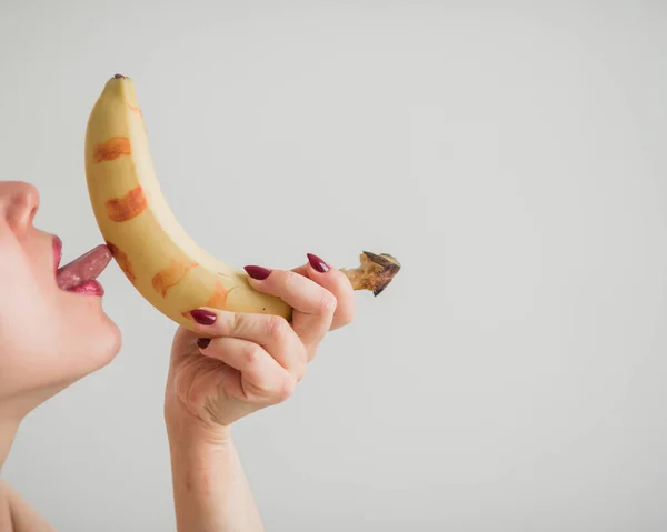 Adulto europeo ragazza lecca sessualmente e succhia una grande banana. Fantasie sul sesso orale. Primo piano del viso . — Foto Stock