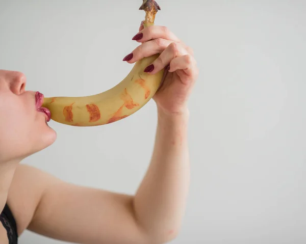 Vuxen europeisk flicka slickar sexuellt och suger en stor banan. Fantasier om oralsex. Ansikte närbild. — Stockfoto