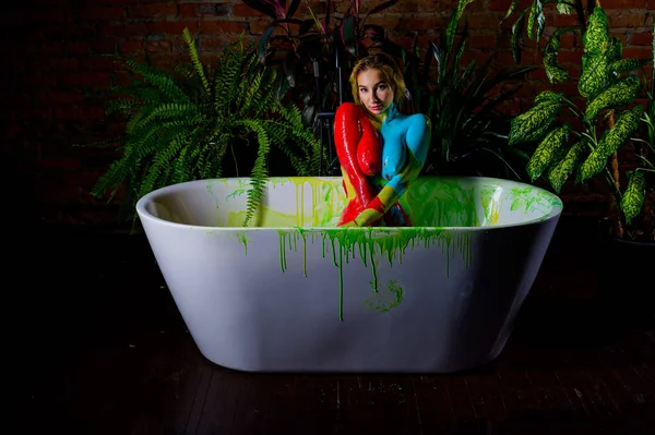 Beautiful woman posing naked in the bathroom against the background of houseplants. On the naked body of a female, streaks of paint flow down. Body painting on a girl body. — 스톡 사진