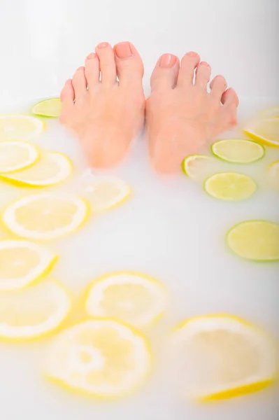 Девушка принимает молочную ванну с лимонами и лаймами. Fabrus spa. Уход за телом. Отбеливание кожи. Женские ноги. — стоковое фото