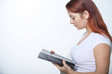 Yüzünde Kineisio bandı olan bir kadın dergi okuyor. Yüz kırışıklıklarına karşı yüz uygulaması.