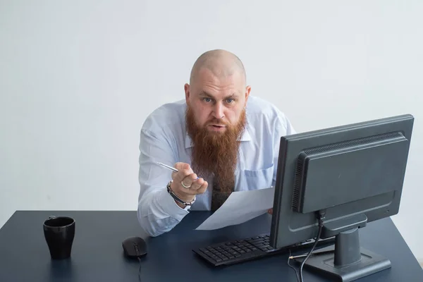 Porträtt av en skallig man vid ett skrivbord som tittar på en rapport och svär. Den missnöjda chefen rapporterar till de underordnade. — Stockfoto