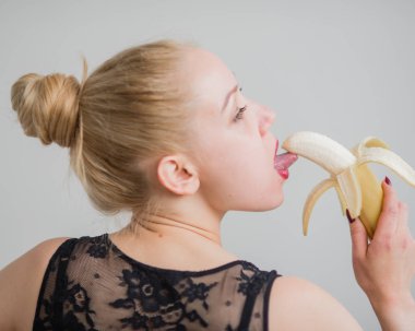 Siyah dantelli iç çamaşırlı bir sarışın baştan çıkarıcı bir şekilde muz yalıyor. Şehvetli kırmızılı kadın oral zevki taklit eder..