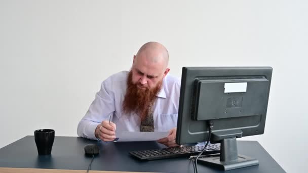 Porträtt av en skallig man vid ett skrivbord som tittar på en rapport och svär. Den missnöjda chefen rapporterar till de underordnade. — Stockvideo
