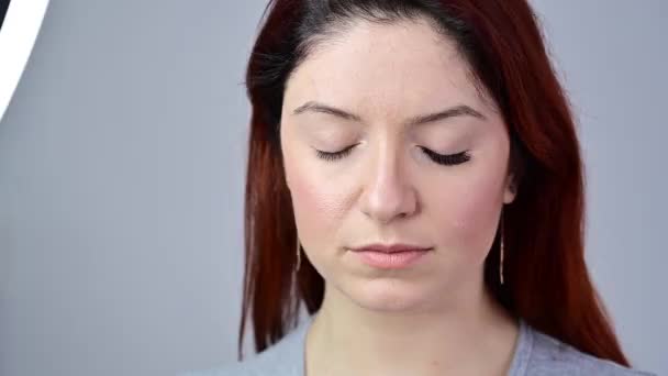 Porträt einer Frau bei der Wimpernverlängerung. Bevor nach der Erhöhung des Volumens der Wimpern. Das Mädchen öffnet die Augen mit einem aufgemalten Auge. — Stockvideo