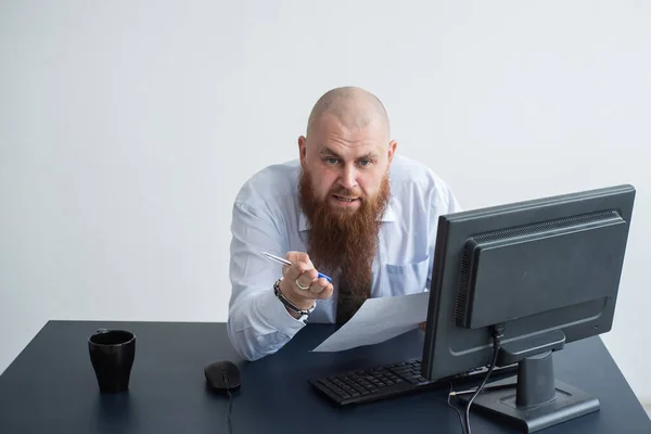 Porträtt av en skallig man vid ett skrivbord som tittar på en rapport och svär. Den missnöjda chefen rapporterar till de underordnade. — Stockfoto