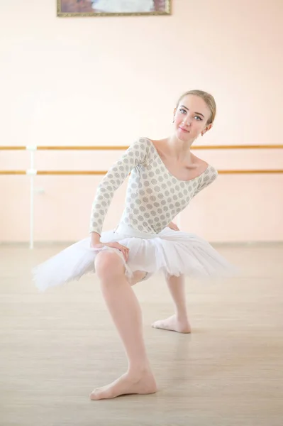 Bardzo elastyczna baletnica w tutu stoi w plie w klasie z maszynami baletowymi. Niesamowicie tancerz z tworzywa sztucznego. — Zdjęcie stockowe