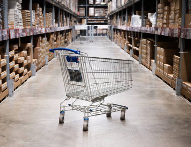 Mobilya deposunda boş bir alışveriş arabası. Kutu rafı soyut bulanık arka planla süpermarket alışveriş sepeti koridoru