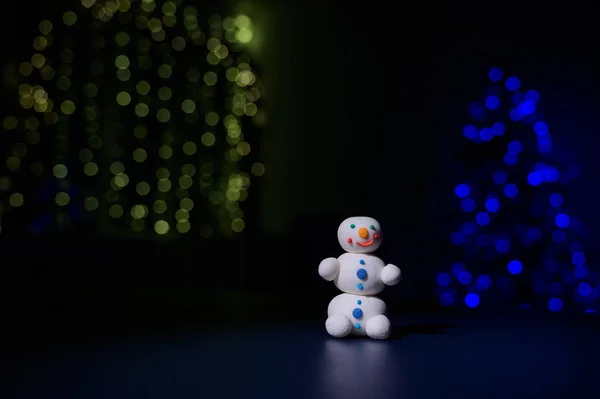 Bonhomme de neige mignon et petits arbres de Noël faits de guimauves sur le fond des lumières de Noël. Tasse blanche de chocolat chaud et de bonbons. — Photo