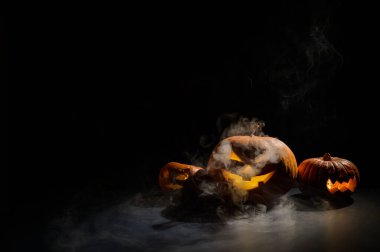 Siste üç cadılar bayramı balkabağı. Geleneksel tatil süsü. Tebrik kartı olarak kullanışlı. Jack-o-fener sigara içiyor..